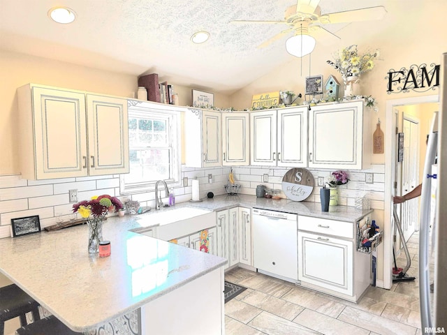 kitchen featuring sink, backsplash, white dishwasher, kitchen peninsula, and a breakfast bar