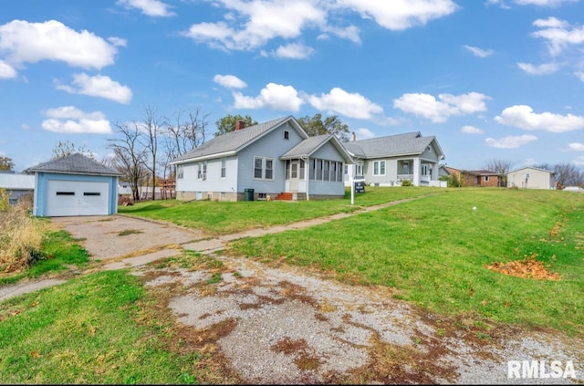 view of front of house featuring a garage, an outdoor structure, and a front yard