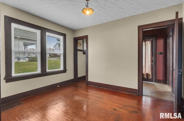 spare room with dark wood-type flooring and a textured ceiling