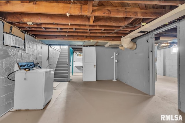 basement with washer / clothes dryer and a wall mounted air conditioner