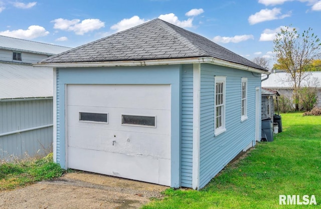 view of property exterior featuring a garage, an outdoor structure, and a lawn