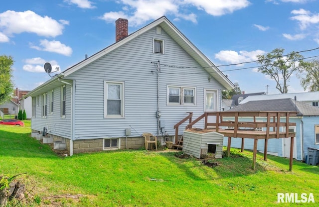 rear view of property featuring a lawn and a wooden deck