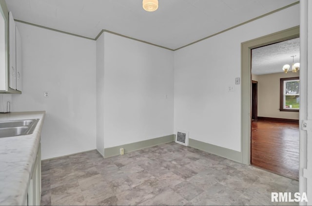 interior space with a textured ceiling, light hardwood / wood-style flooring, sink, and a chandelier