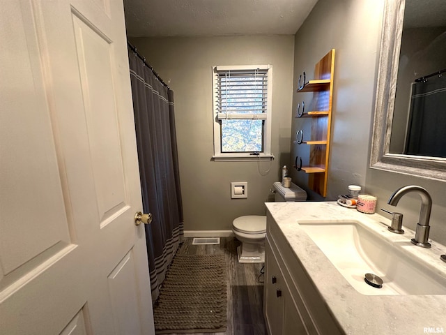 bathroom featuring vanity, hardwood / wood-style floors, and toilet