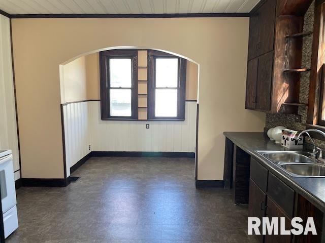 kitchen with sink, dark brown cabinetry, crown molding, and wood ceiling