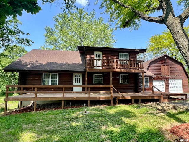 back of house featuring a garage, a deck, and a lawn