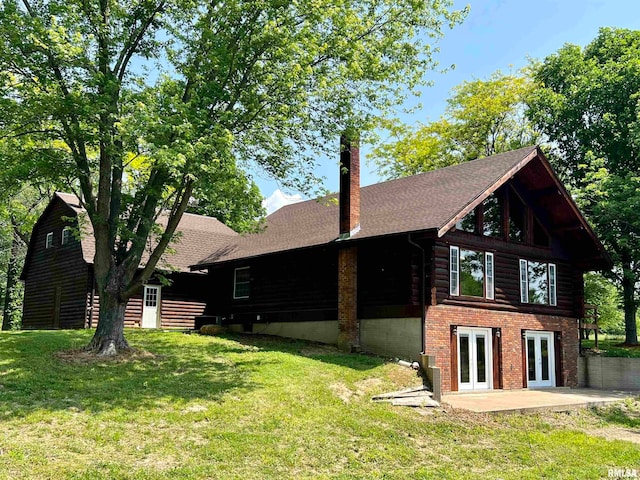 view of home's exterior with a yard, a patio, and french doors