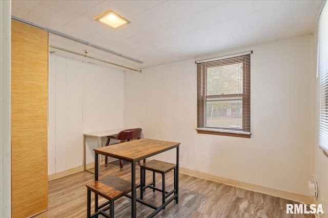 dining room with wood walls and wood-type flooring