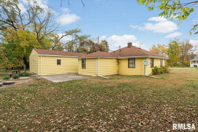 back of property featuring a lawn and a patio