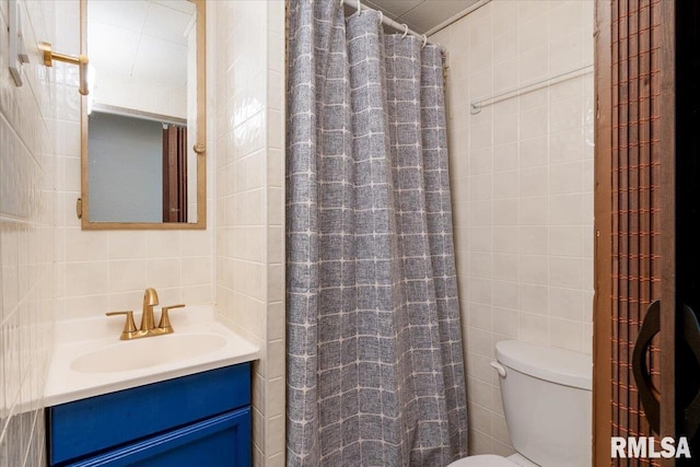 bathroom with a shower with curtain, vanity, toilet, and tile walls