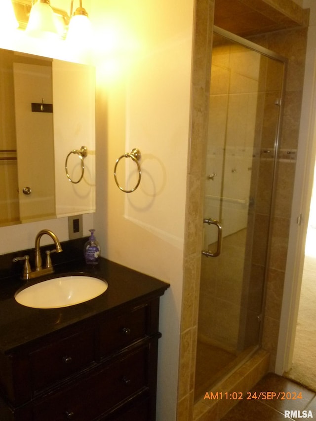 bathroom featuring vanity and a shower with door