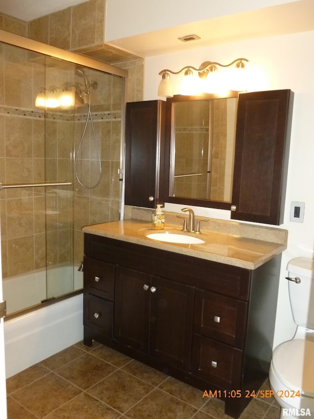 full bathroom with toilet, combined bath / shower with glass door, vanity, and tile patterned floors