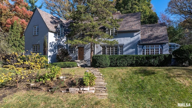 english style home featuring a front yard