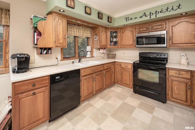 kitchen with black appliances, decorative backsplash, crown molding, and sink