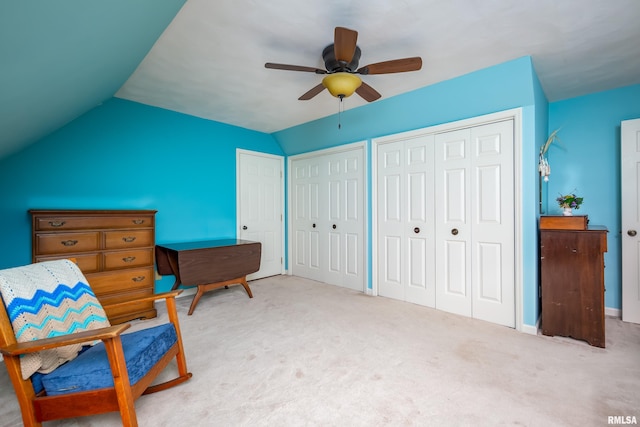 sitting room with ceiling fan, light colored carpet, and vaulted ceiling