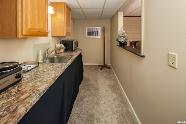 kitchen featuring light colored carpet, a drop ceiling, and sink