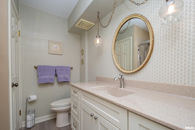 bathroom with toilet, vanity, and hardwood / wood-style flooring