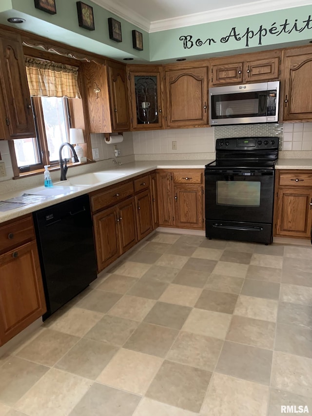 kitchen with tasteful backsplash, crown molding, sink, and black appliances