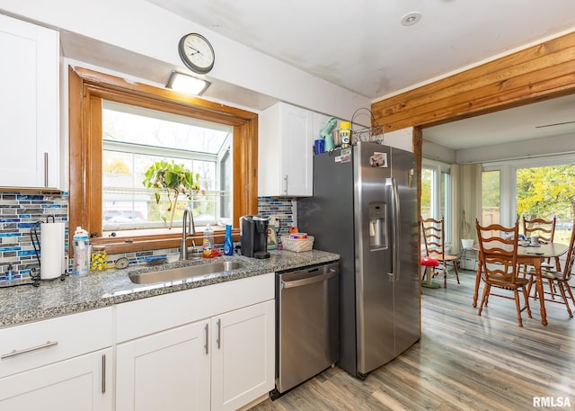 kitchen with a healthy amount of sunlight, sink, white cabinetry, and stainless steel appliances