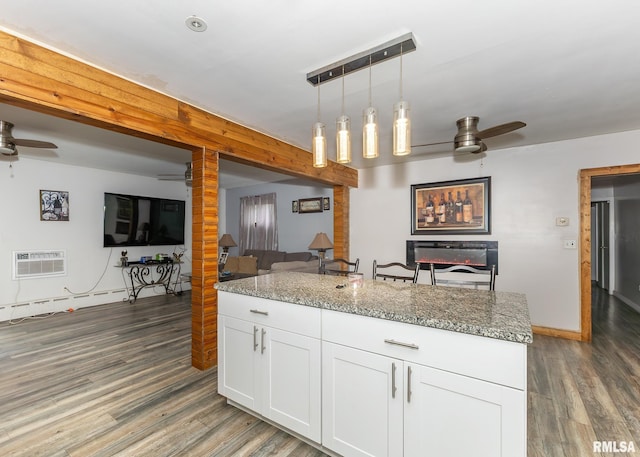 kitchen featuring light stone countertops, white cabinets, pendant lighting, and dark hardwood / wood-style floors