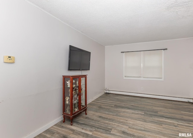 living room with hardwood / wood-style floors, a textured ceiling, and baseboard heating