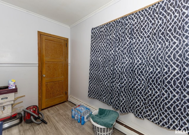 miscellaneous room with light wood-type flooring, ornamental molding, and a baseboard heating unit