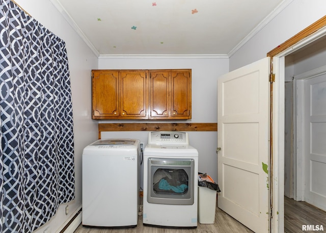 washroom with light hardwood / wood-style floors, ornamental molding, and washing machine and clothes dryer