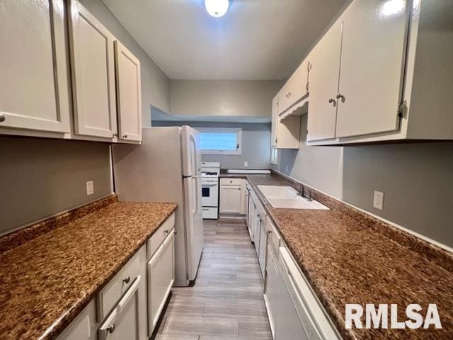 kitchen with white cabinetry, sink, dark stone counters, white range oven, and light wood-type flooring