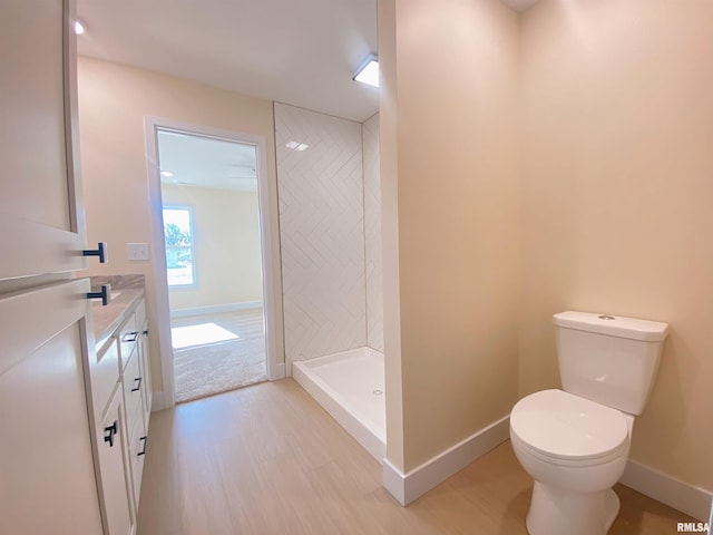 bathroom with vanity, toilet, wood-type flooring, and a shower