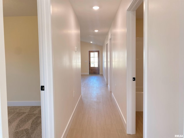 hall featuring light hardwood / wood-style flooring and lofted ceiling