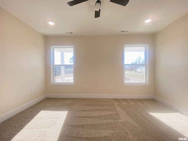 carpeted empty room with plenty of natural light and ceiling fan