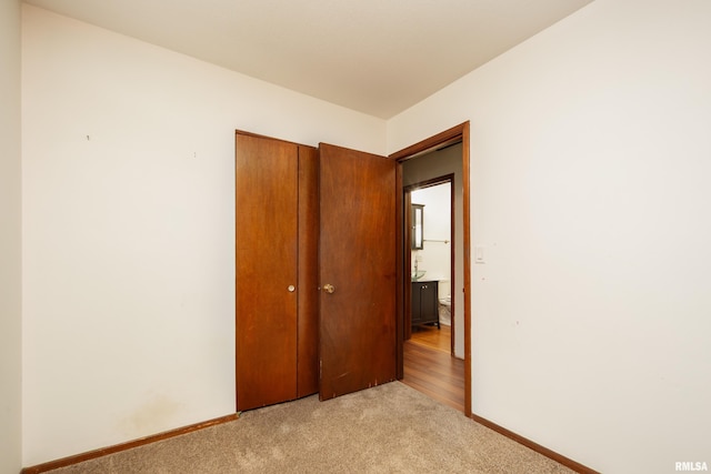 unfurnished bedroom featuring a closet and light carpet