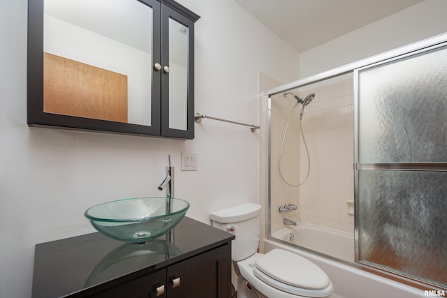 full bathroom with enclosed tub / shower combo, toilet, and vanity