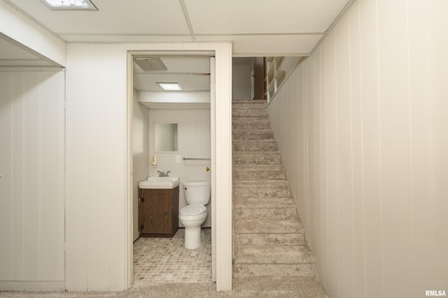 stairs featuring wooden walls and sink