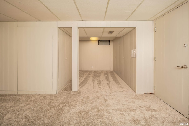 basement with wooden walls and light carpet