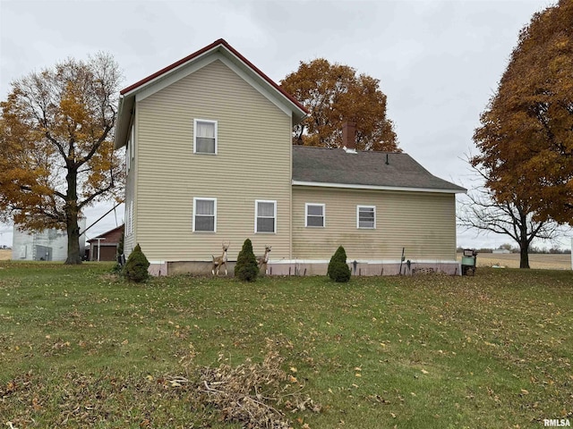 rear view of property featuring a lawn