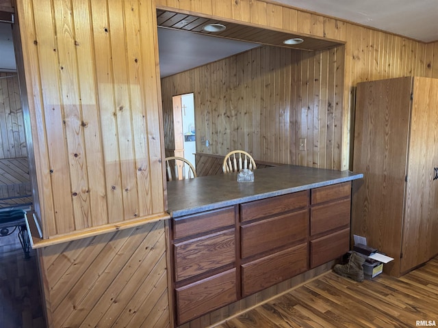 kitchen featuring hardwood / wood-style floors and wood walls