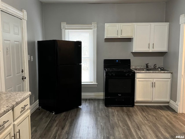 kitchen featuring black appliances, dark hardwood / wood-style flooring, sink, and a wealth of natural light