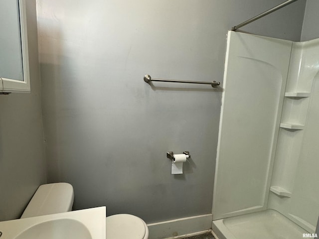 bathroom featuring a shower and toilet