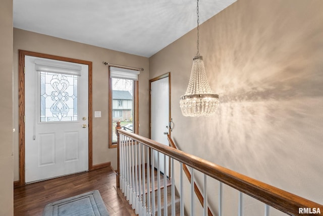 foyer with dark wood-type flooring and a notable chandelier