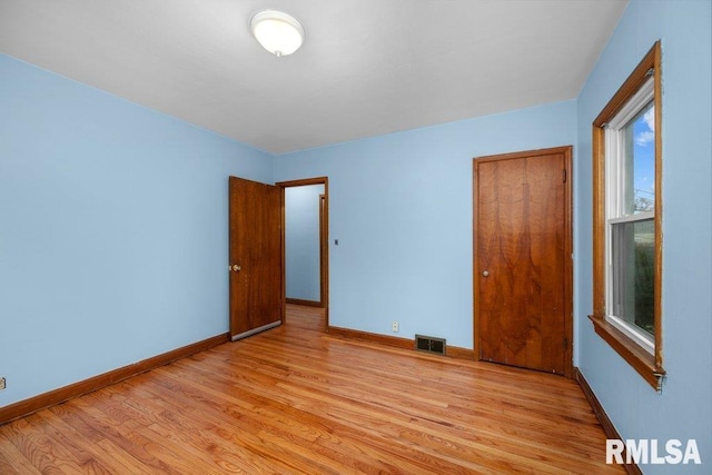 unfurnished bedroom with a closet and light hardwood / wood-style flooring