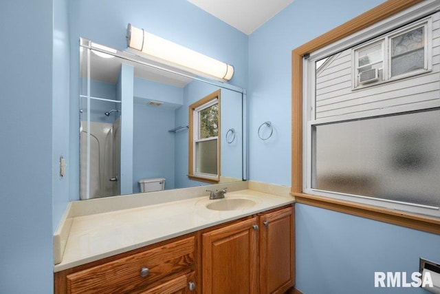 bathroom with a shower, vanity, and toilet