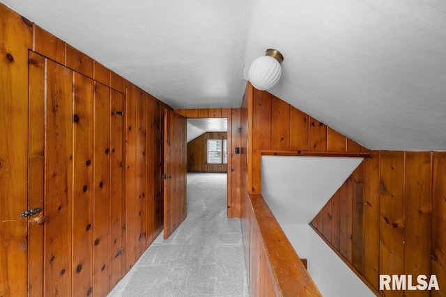 hallway with wood walls and light colored carpet