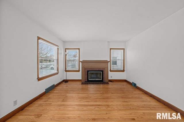 unfurnished living room featuring a fireplace and light hardwood / wood-style flooring