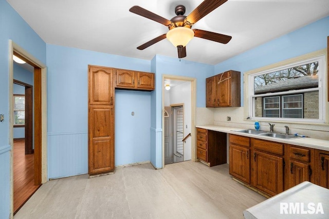 kitchen featuring ceiling fan, decorative backsplash, sink, and light hardwood / wood-style flooring