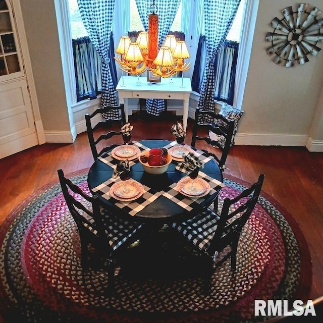 dining area featuring dark hardwood / wood-style flooring and a chandelier