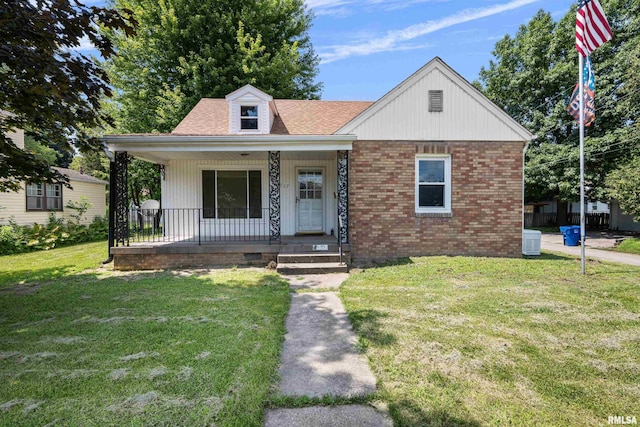 view of front of property with central AC unit, a front lawn, and covered porch