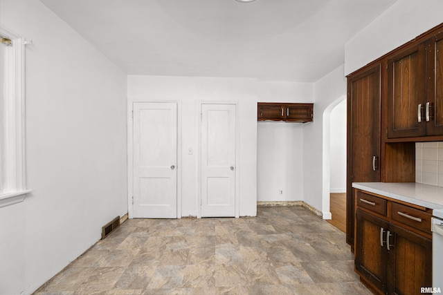 interior space featuring dark brown cabinets and backsplash