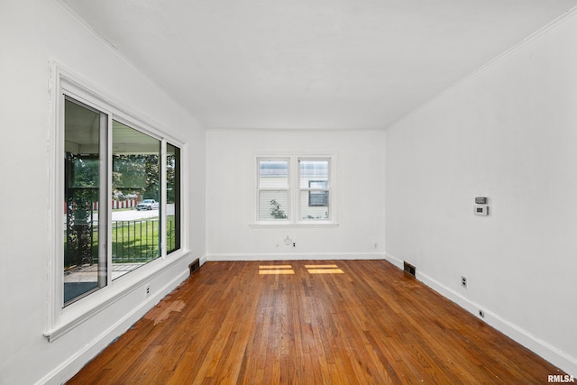 unfurnished room with ornamental molding and hardwood / wood-style flooring