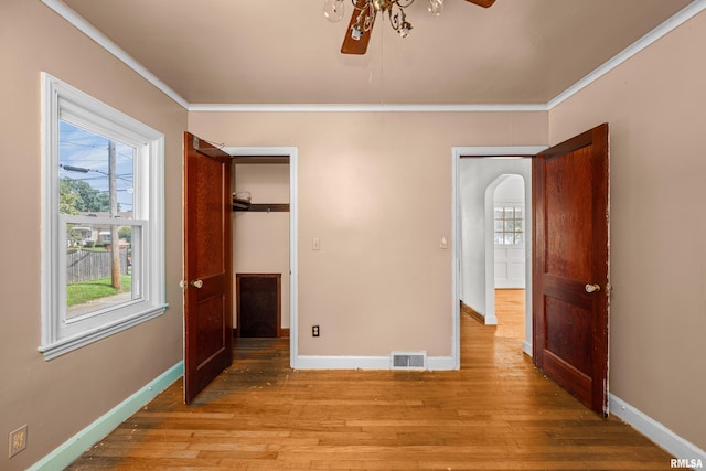 unfurnished bedroom featuring light hardwood / wood-style floors, ceiling fan, a closet, and crown molding